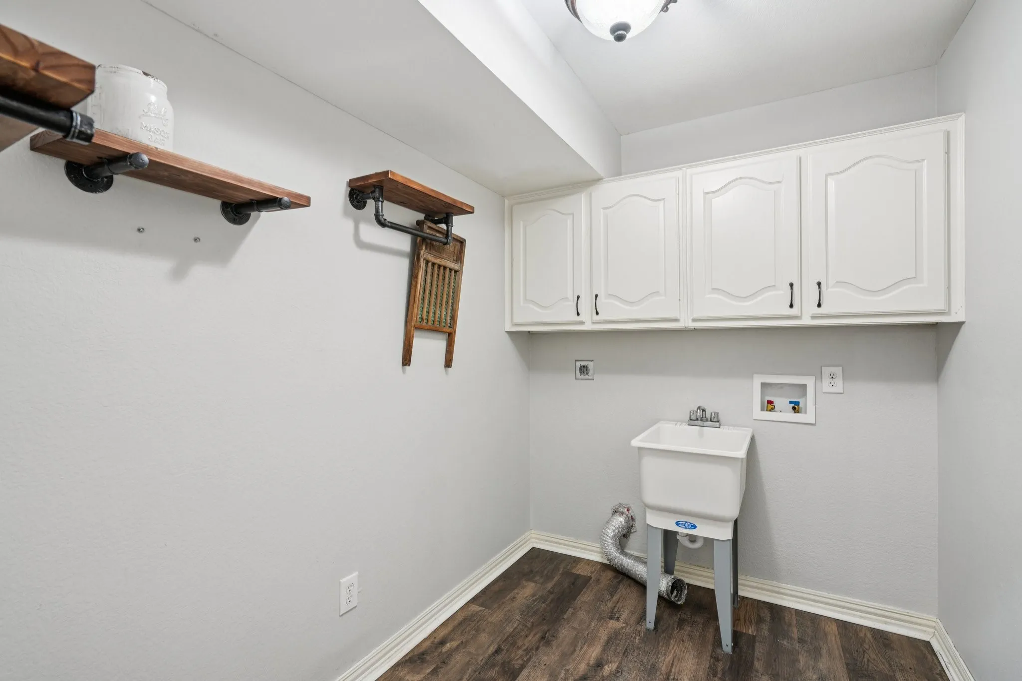 Laundry area LVP flooring, washer/dryer hook-ups and wash tub sink