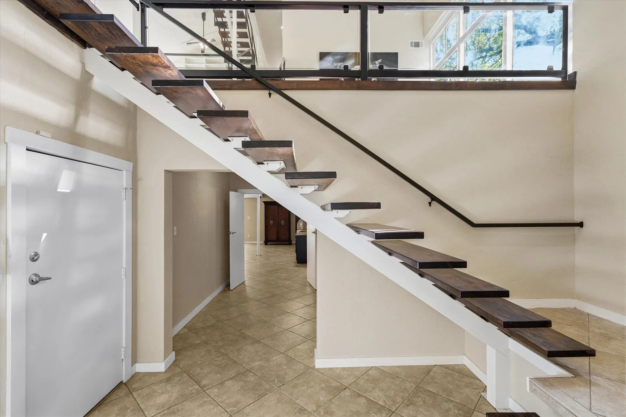 From the first floor entry you can walk to the left, under the staircase, to enter the downstairs 2nd Primary Bedroom which can also be a Family Room. Entry to the 4-car garage is to the left as well.