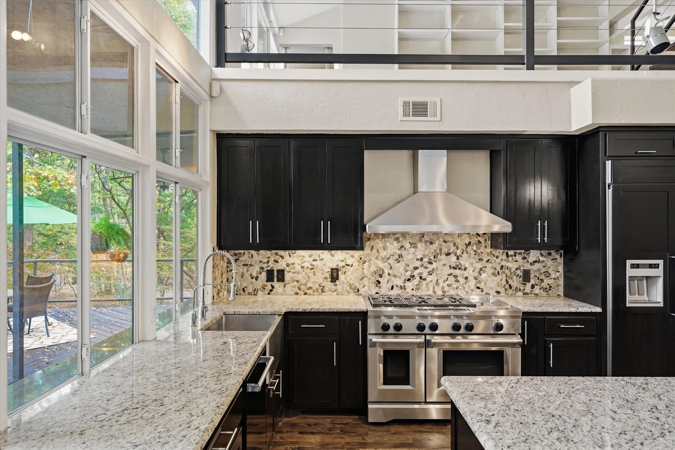 Gourmet Kitchen offers a 6 burner high end gas stove with a commercial grade vent hood. Note the Built-in refrigerator and SS farm sink topped with a wall of windows for year round views.