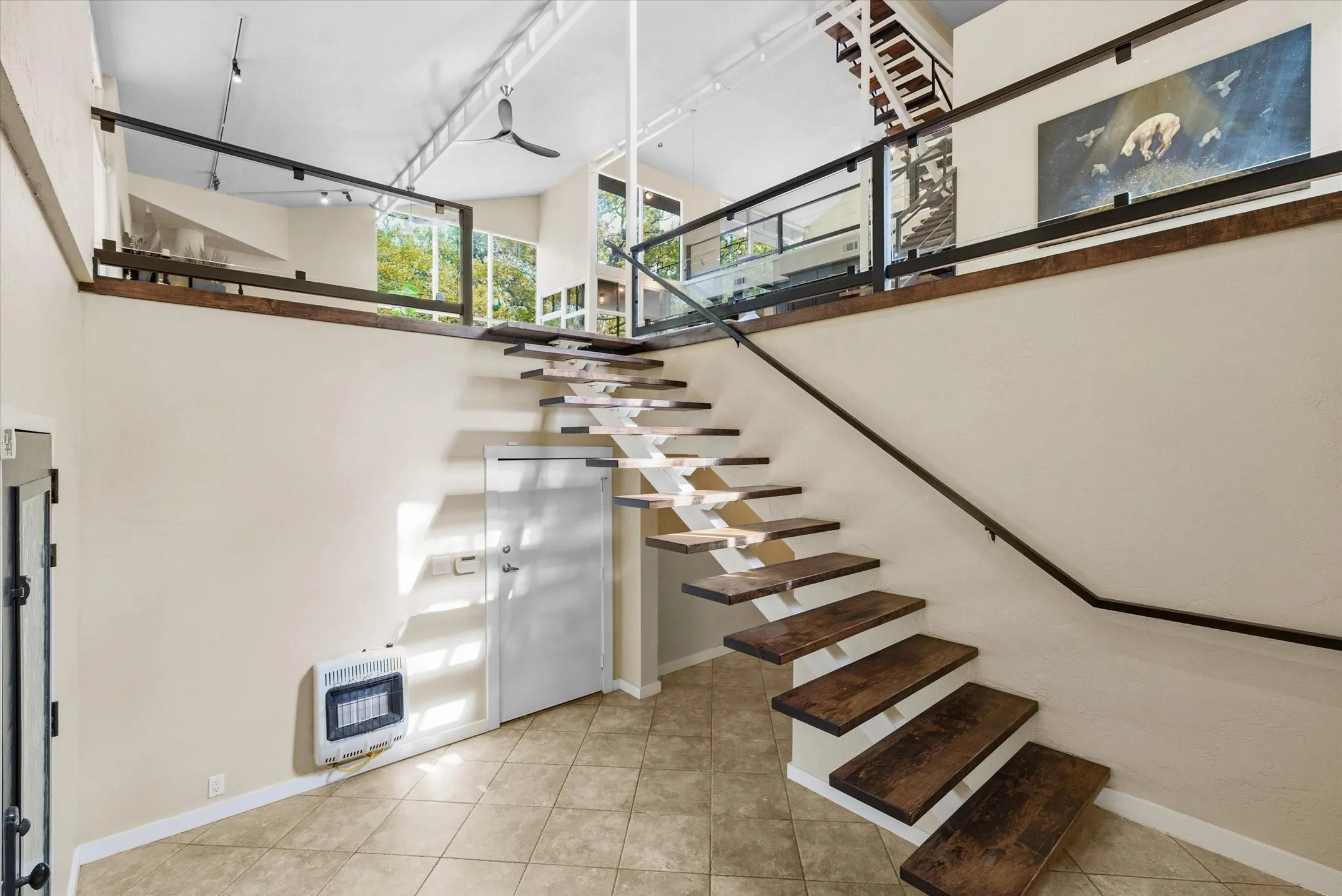 A floating staircase rises from the Entry Foyer to the Main Level Living Spaces
