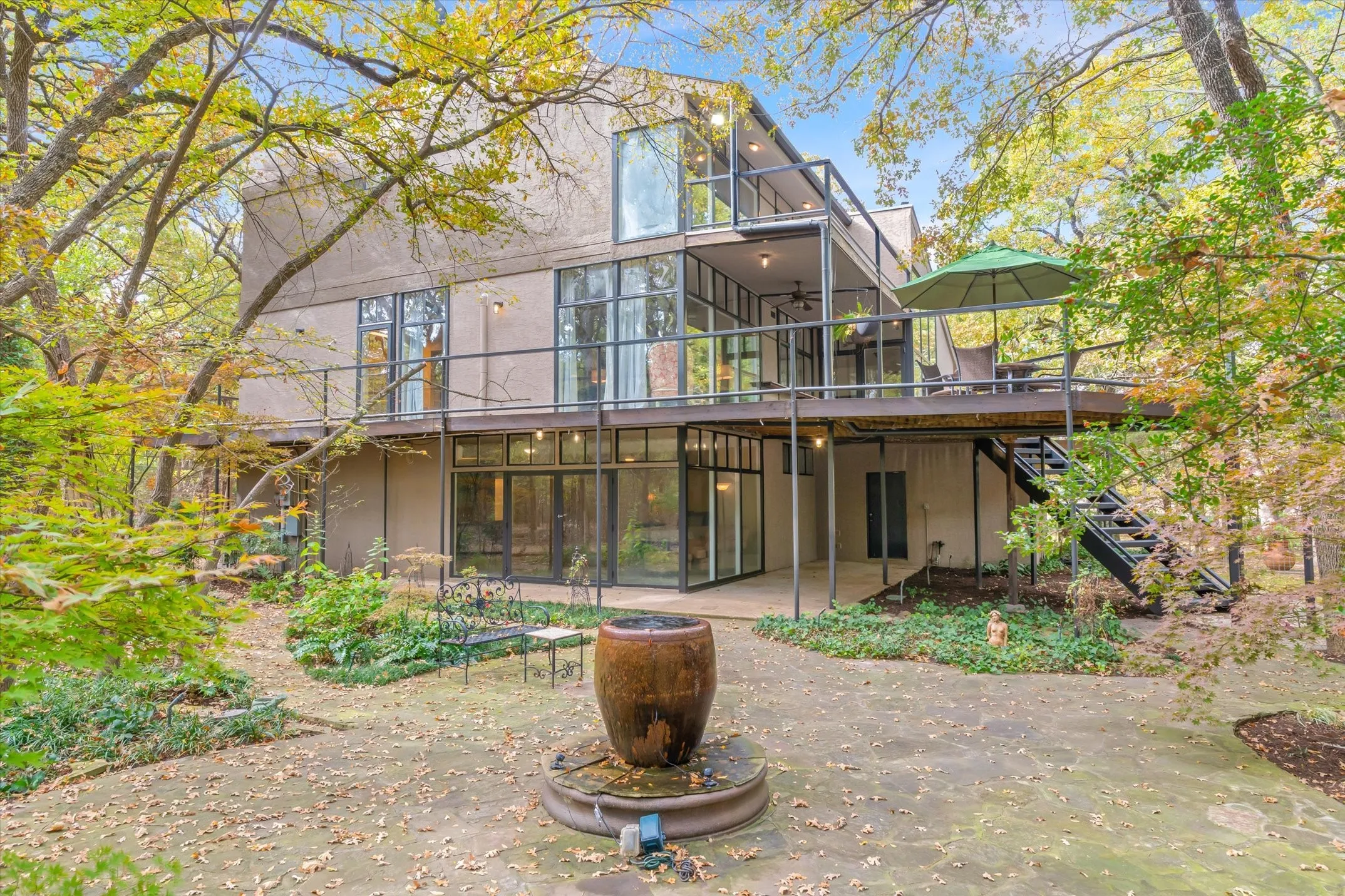 Back flagstone patio is a peaceful retreat with a center fountain, surrounded by foliage and a Japanese Red Maple which turns red in the season.