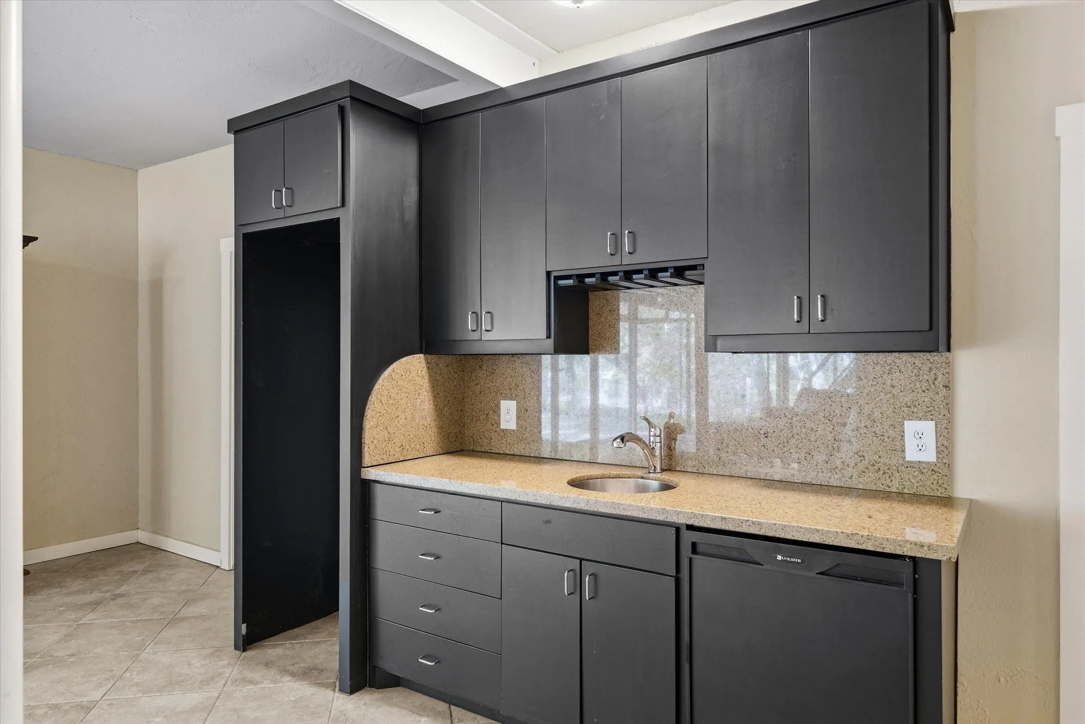 Kitchenette with sink and a space for a frig. means this space could also be used as a separate apartment