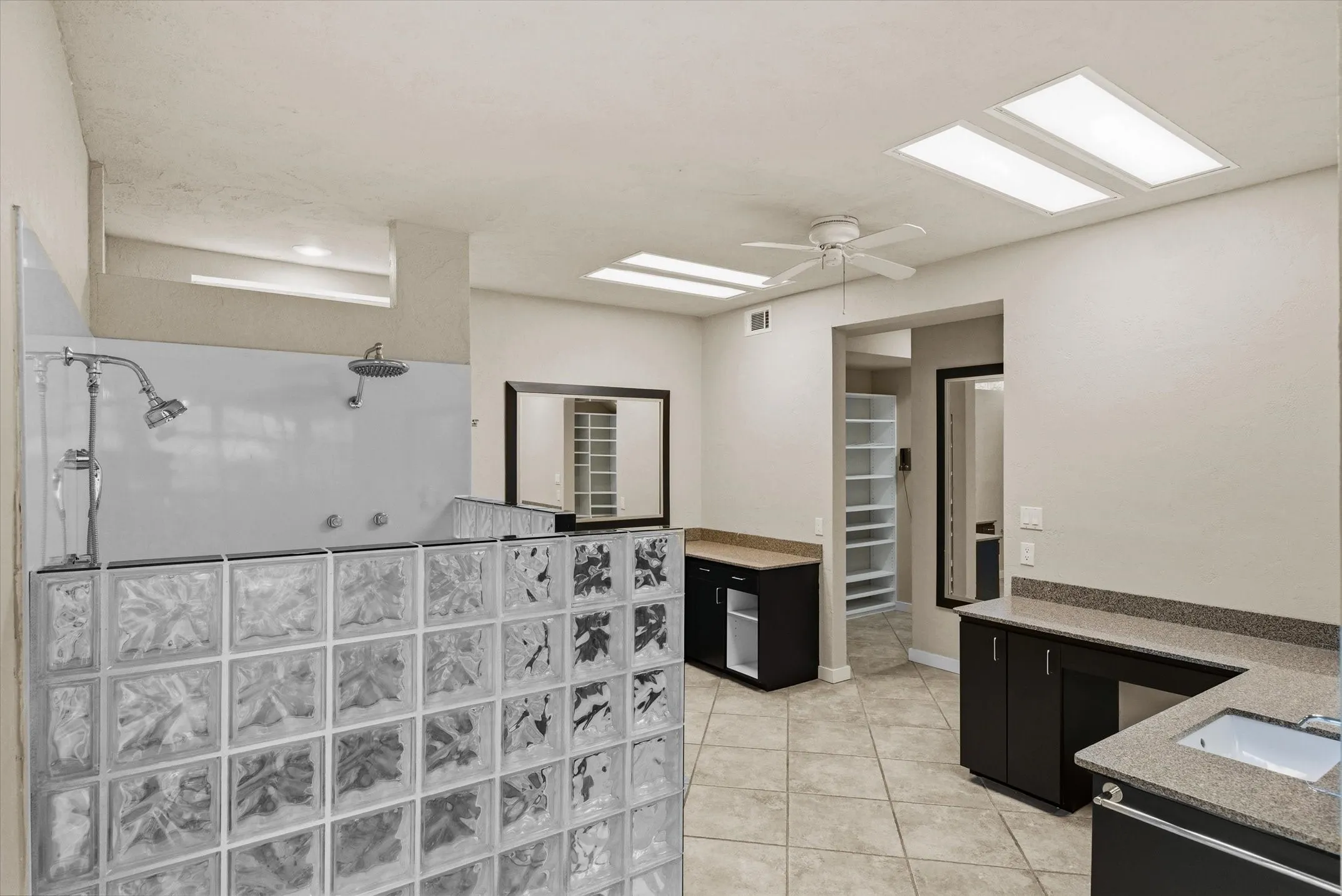 Huge Primary Bathroom with block glass accents and two vanities and huge closet