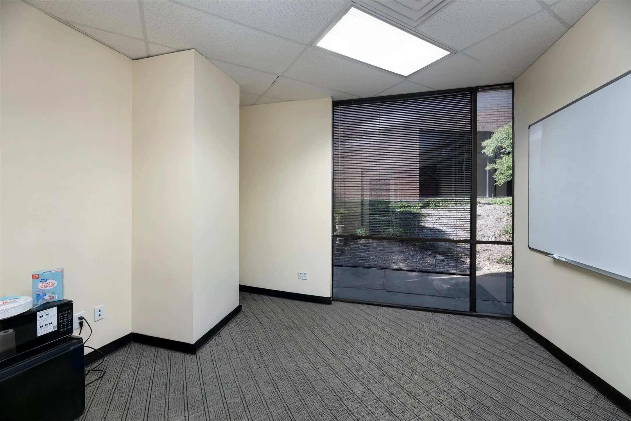 Carpeted spare room featuring baseboards and a paneled ceiling