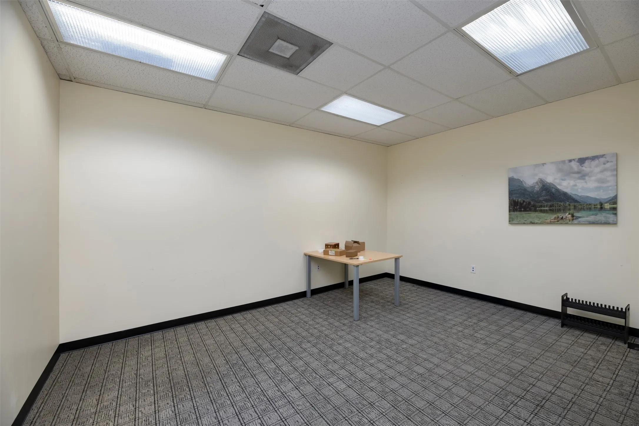 Spare room featuring baseboards and a drop ceiling