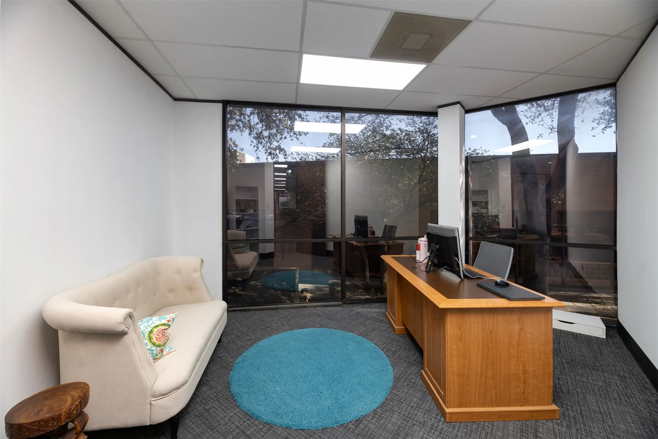 Office area featuring a wall of windows and a drop ceiling