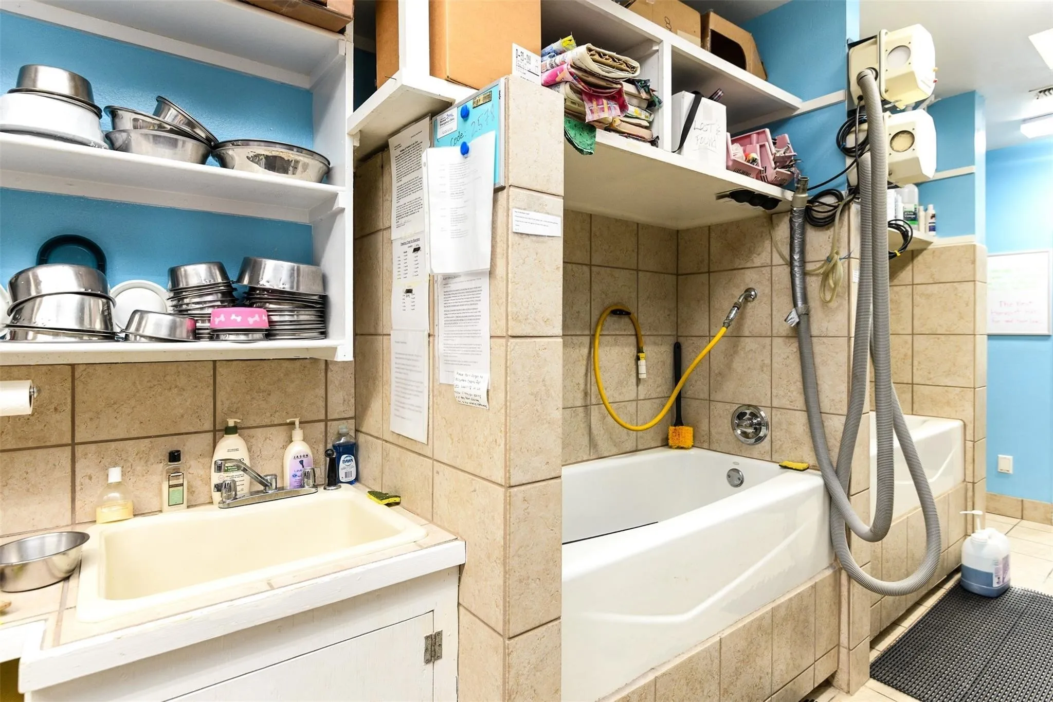 Bathroom featuring tile patterned flooring, shower / bathtub combination with curtain, vanity, and tile walls