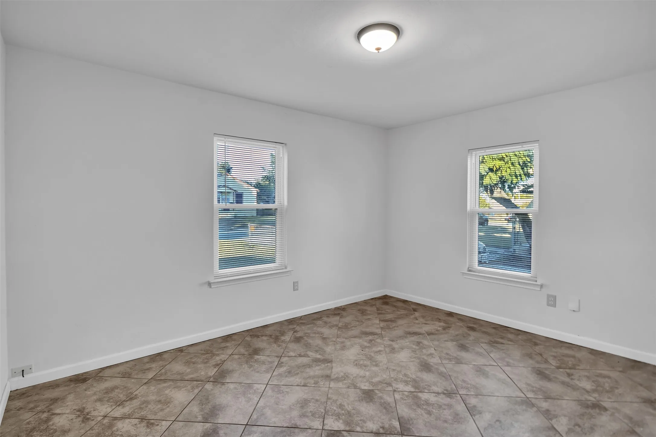 Empty room featuring healthy amount of natural light and light tile patterned floors