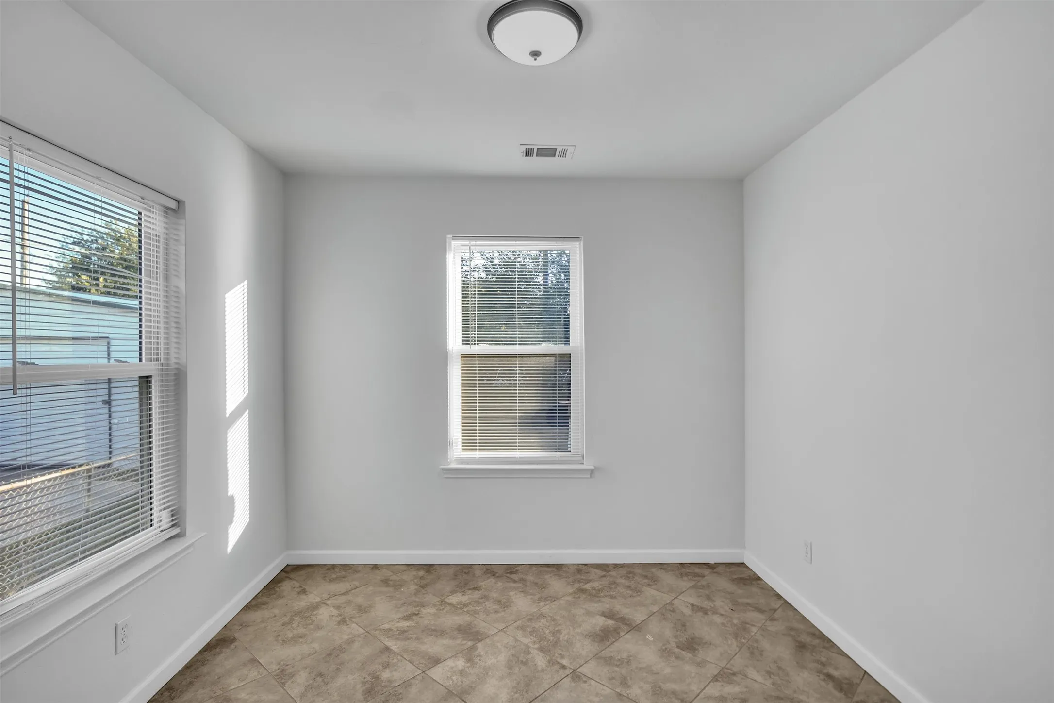 Unfurnished room with baseboards and light tile patterned floors