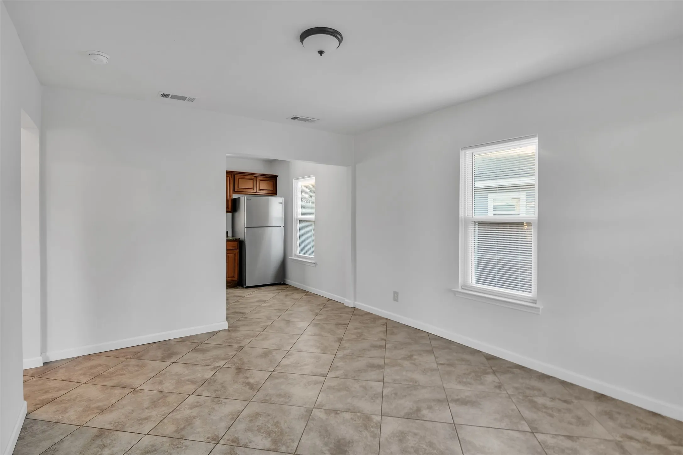 Unfurnished room with healthy amount of natural light and light tile patterned floors