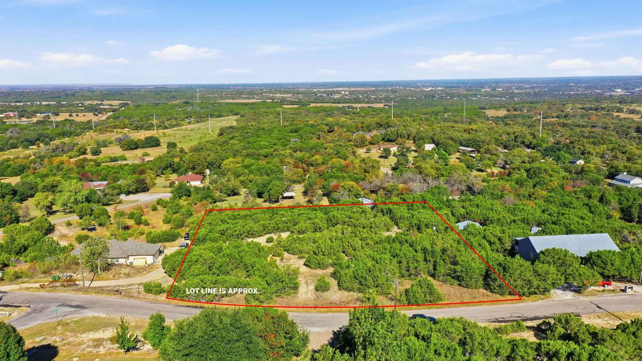 Aerial overview of property's location with property boundaries highlighted and a heavily wooded area