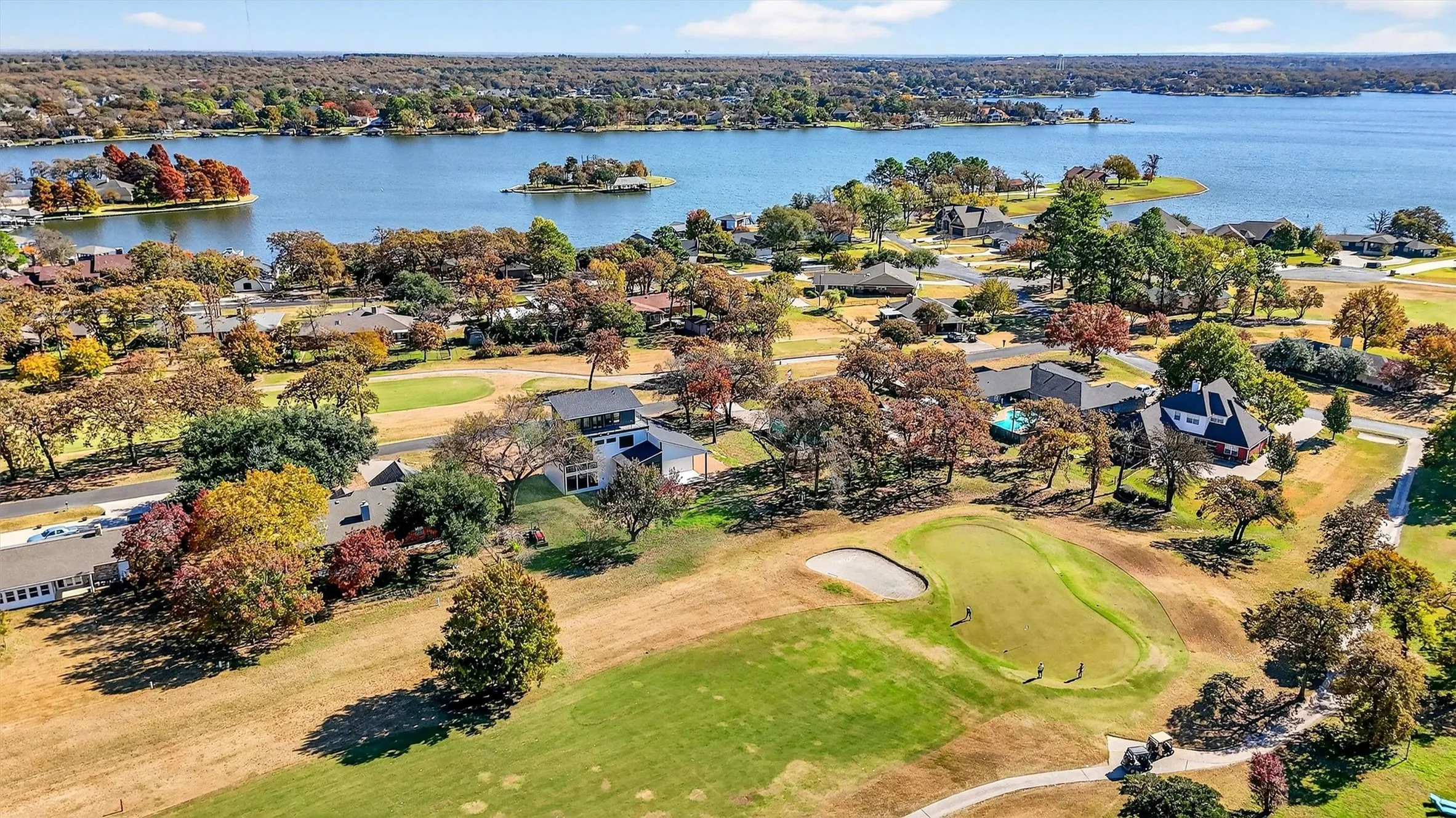 Aerial view of residential area featuring a large body of water and a local golf course