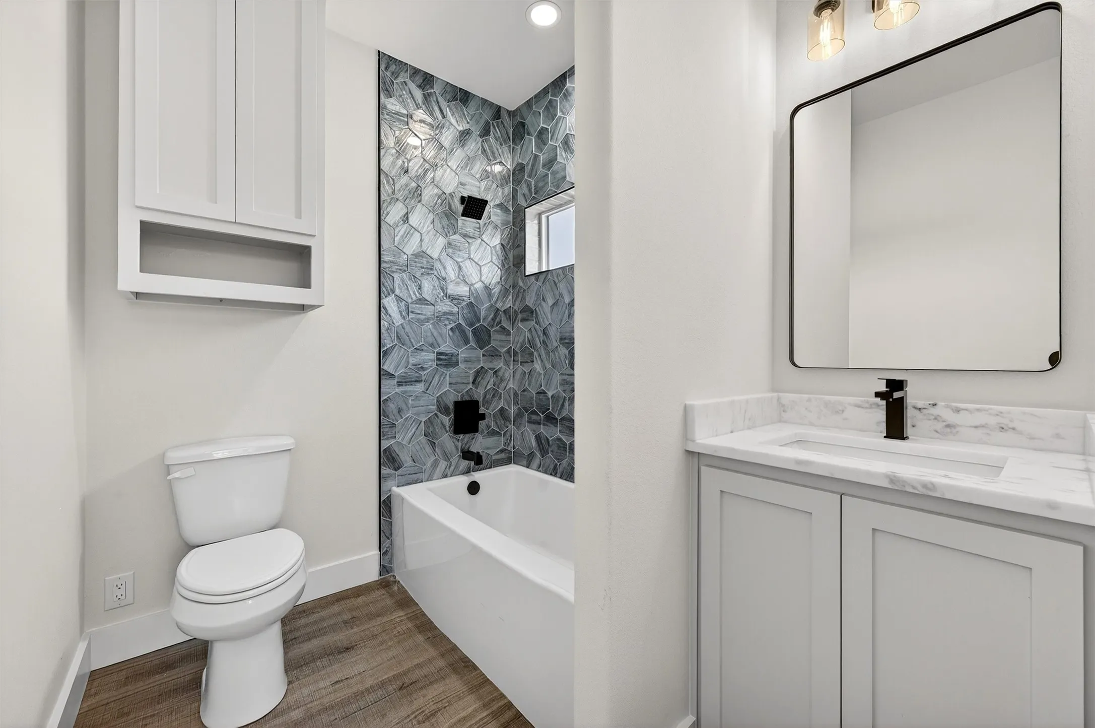 Full bath featuring vanity, shower / washtub combination, and light wood finished floors