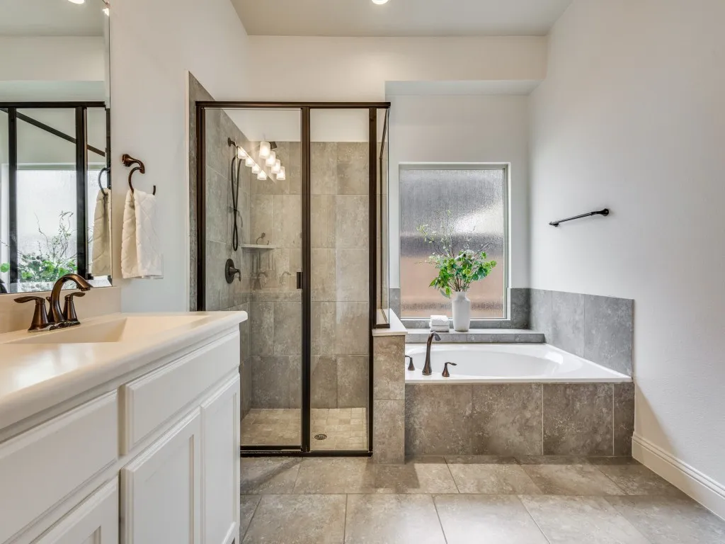 Primary bathroom featuring a tub, vanity, a shower stall, and light tile patterned floors.