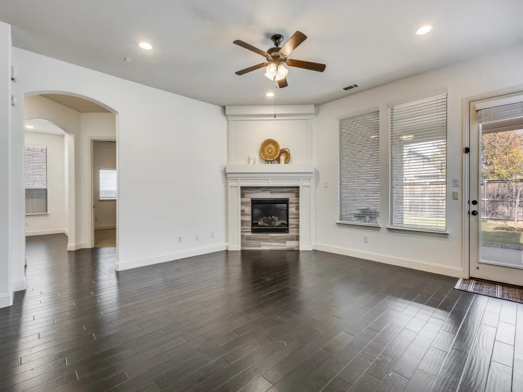 Den with arched walkways, recessed lighting, healthy amount of natural light, ceiling fan, and dark wood-style floors.