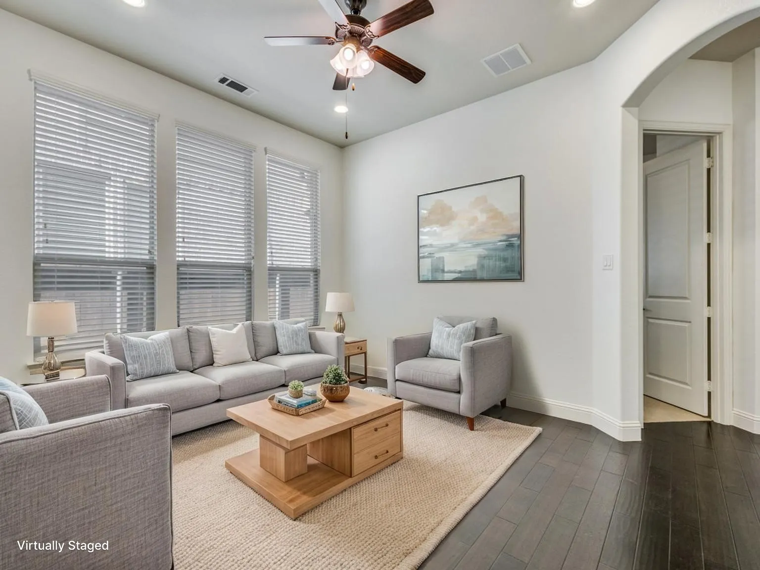 Spacious living area featuring high ceilings, dark wood-finish flooring, and recessed lighting