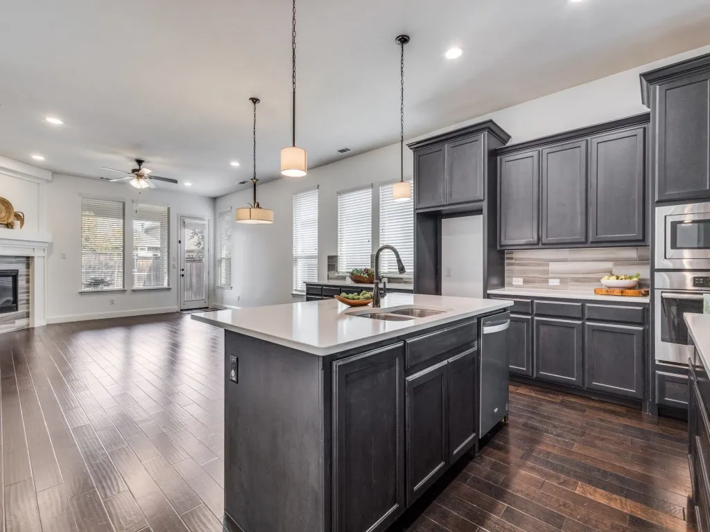 Kitchen with open floor plan, pendant lighting, recessed lighting, stainless steel appliances, and backsplash.