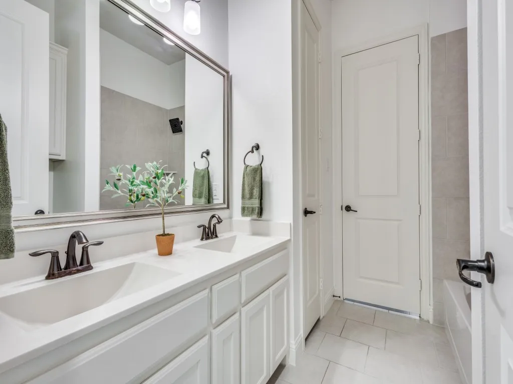 Primary bathroom featuring double vanity and light tile patterned flooring.