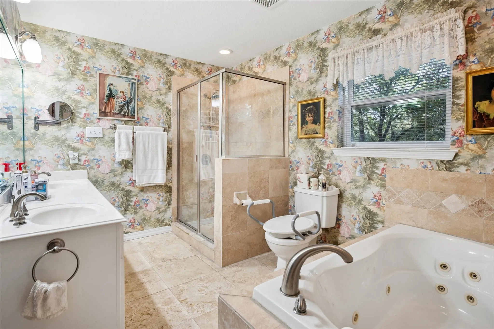Full bath featuring a whirlpool tub, wallpapered walls, double vanity, and a shower stall