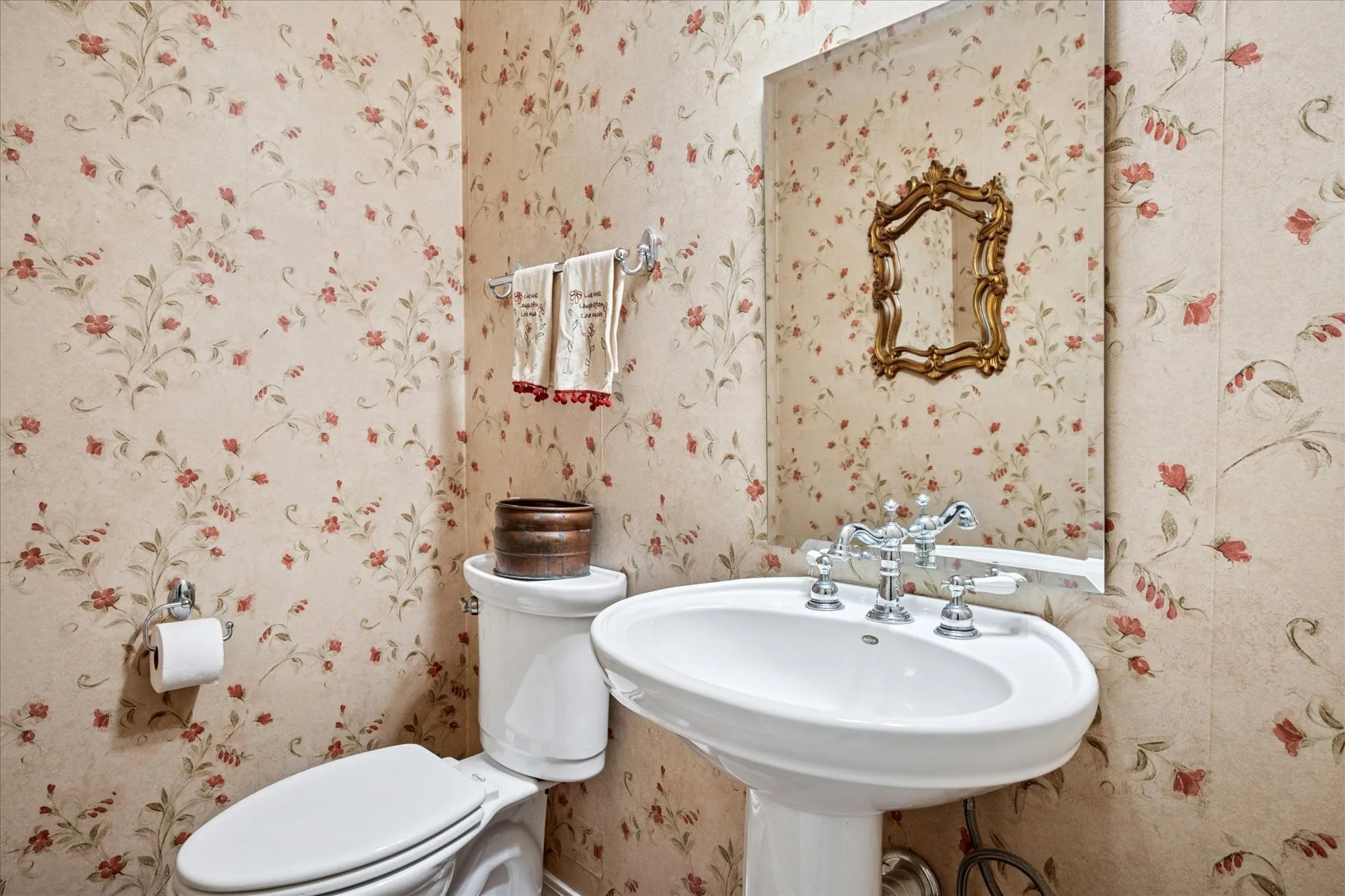 Half bathroom with wallpapered walls and toilet