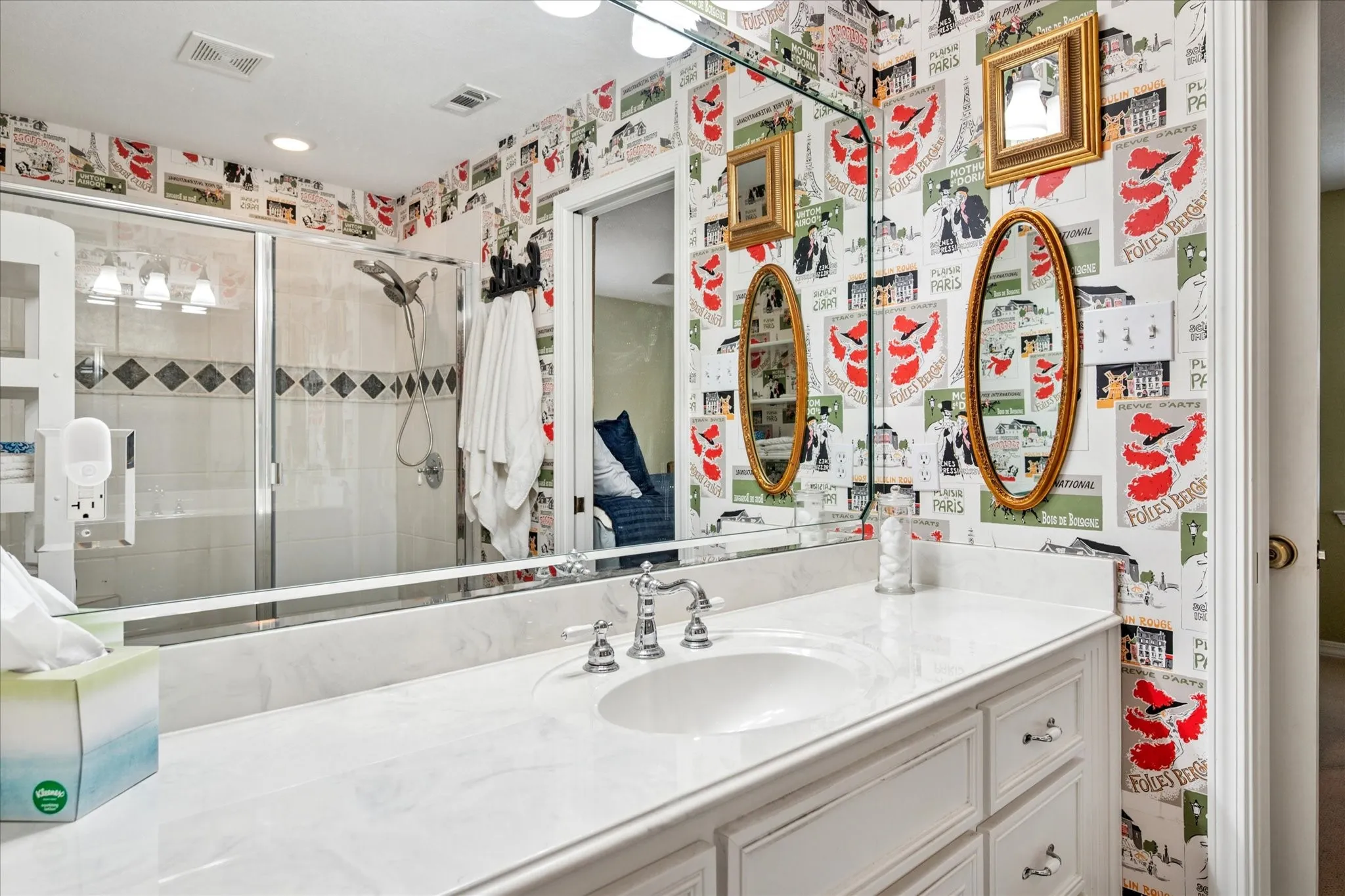 Full bathroom featuring wallpapered walls, a stall shower, and vanity