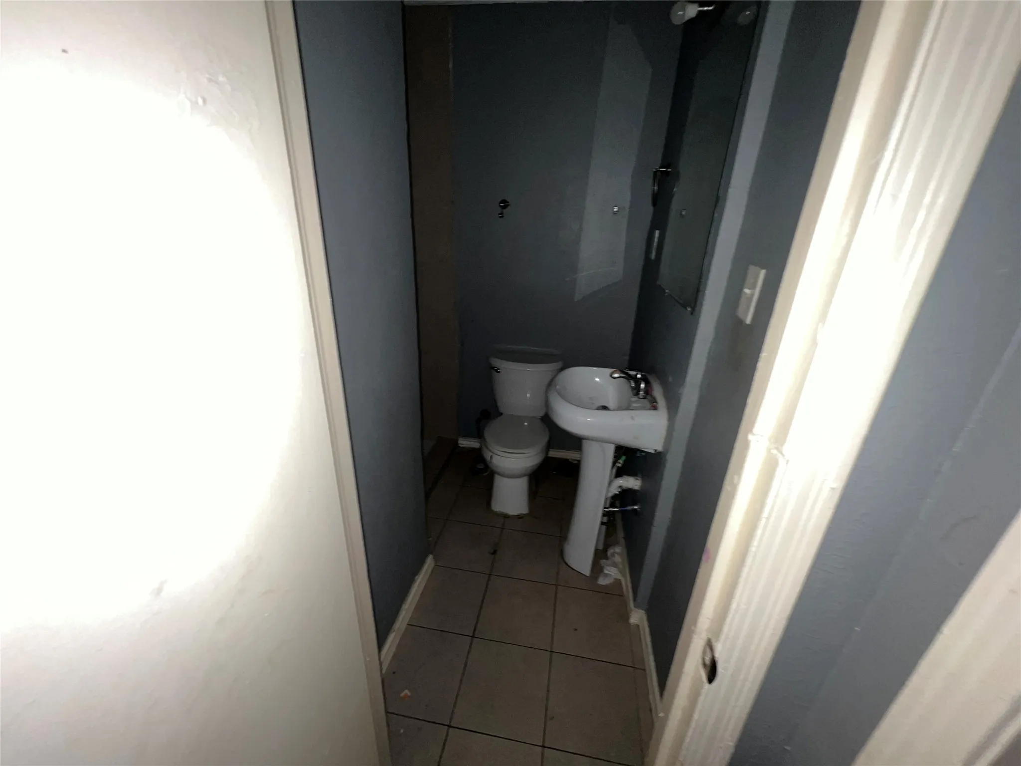 Half bathroom featuring light tile patterned flooring and toilet