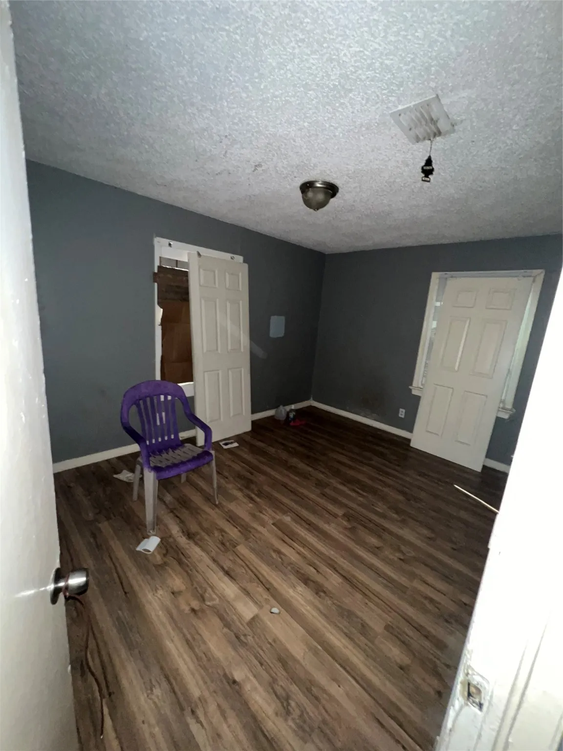 Unfurnished room featuring dark wood-style floors and a textured ceiling