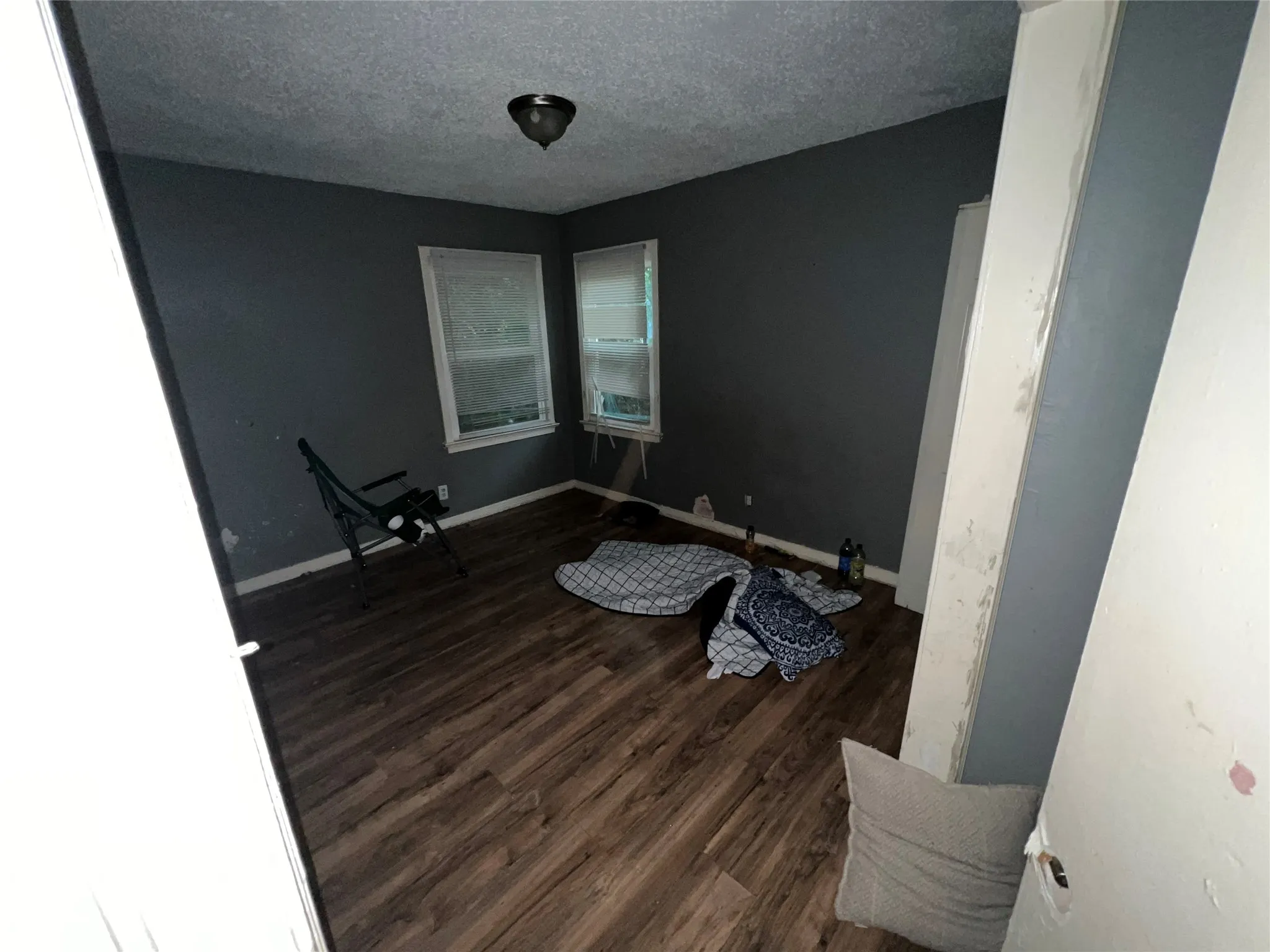 Unfurnished room with dark wood-style flooring and a textured ceiling