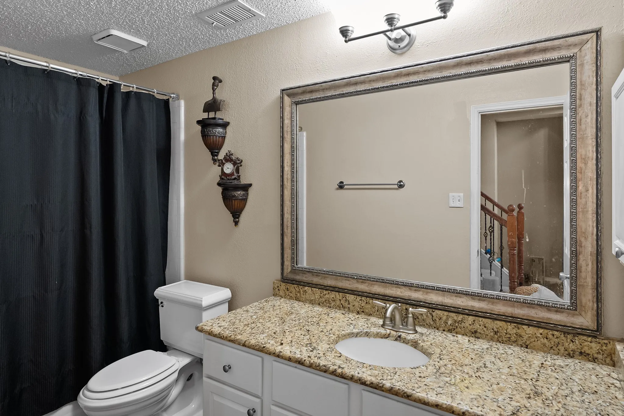Bathroom featuring a shower with curtain, a textured ceiling, and vanity