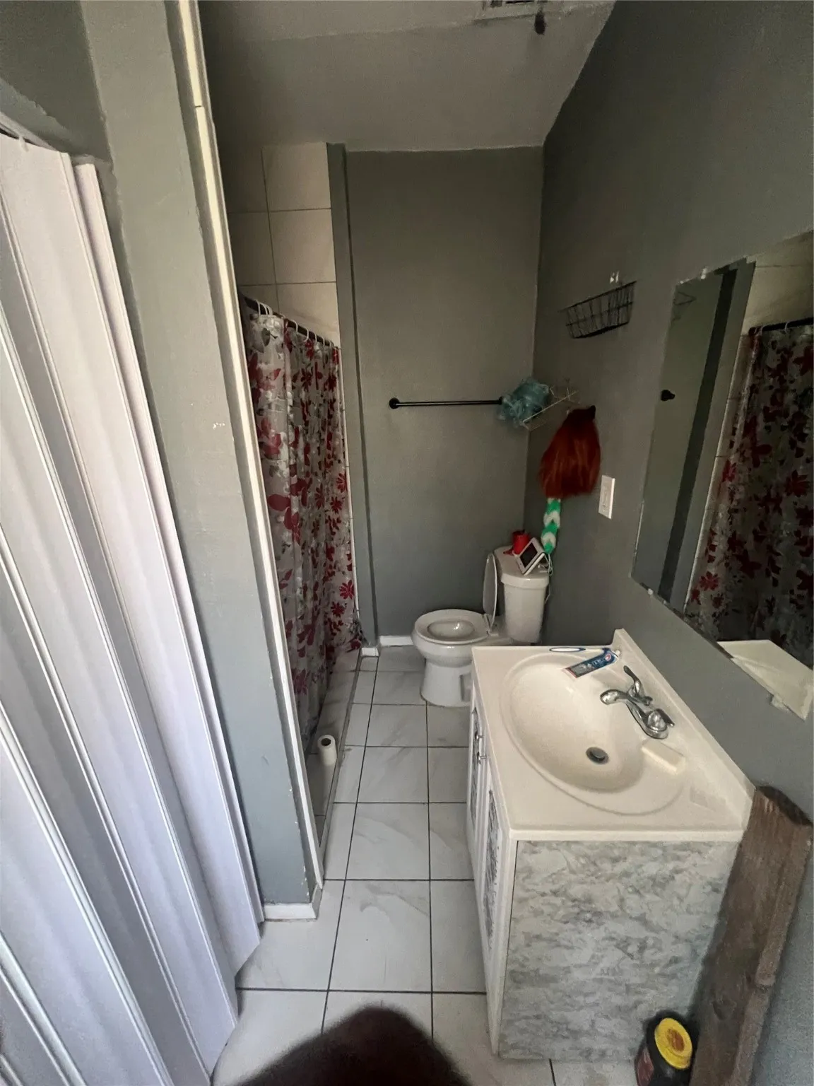 Bathroom featuring curtained shower, vanity, and light tile patterned flooring