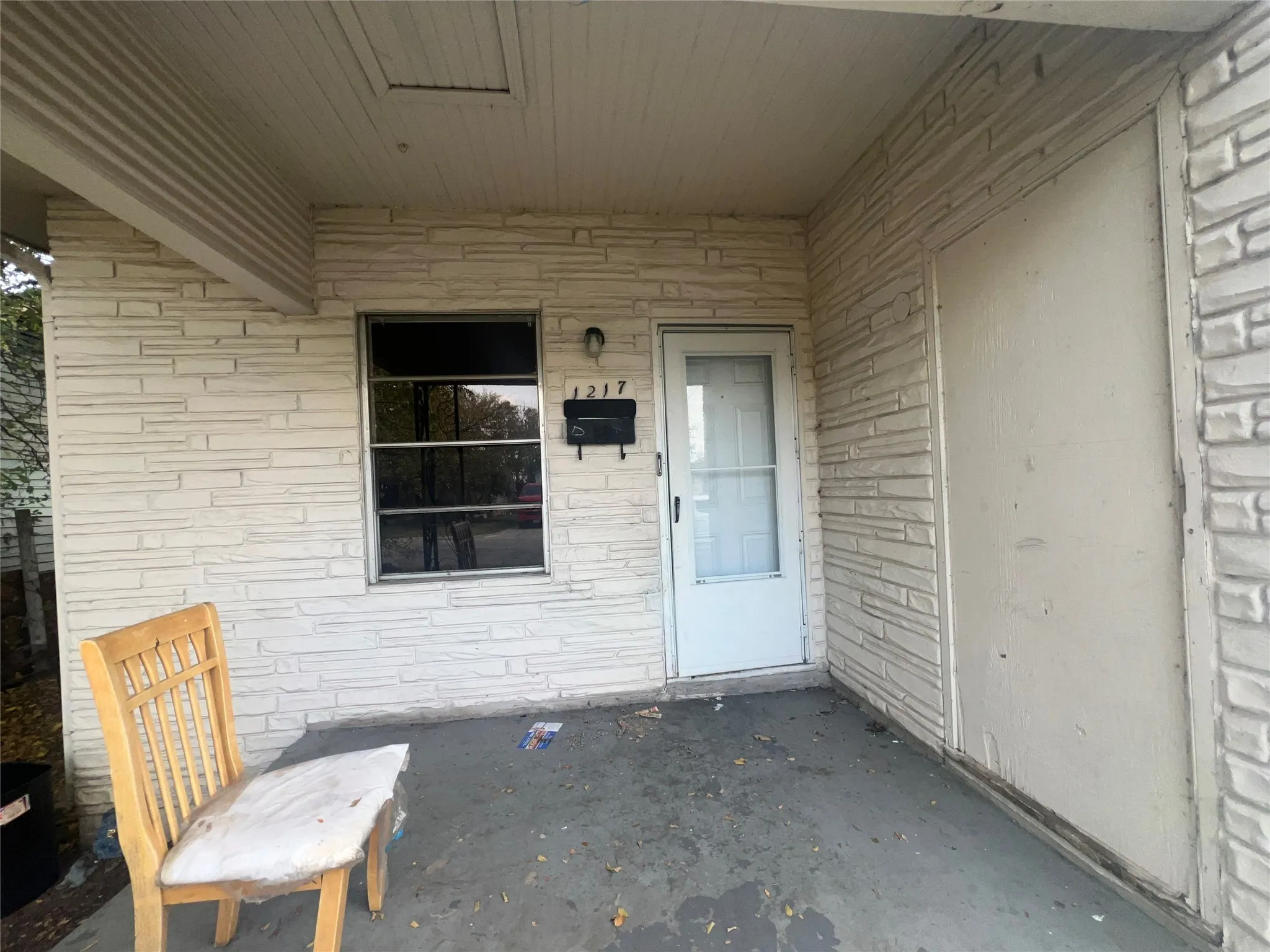 Doorway to property featuring brick siding, a patio, and stone siding