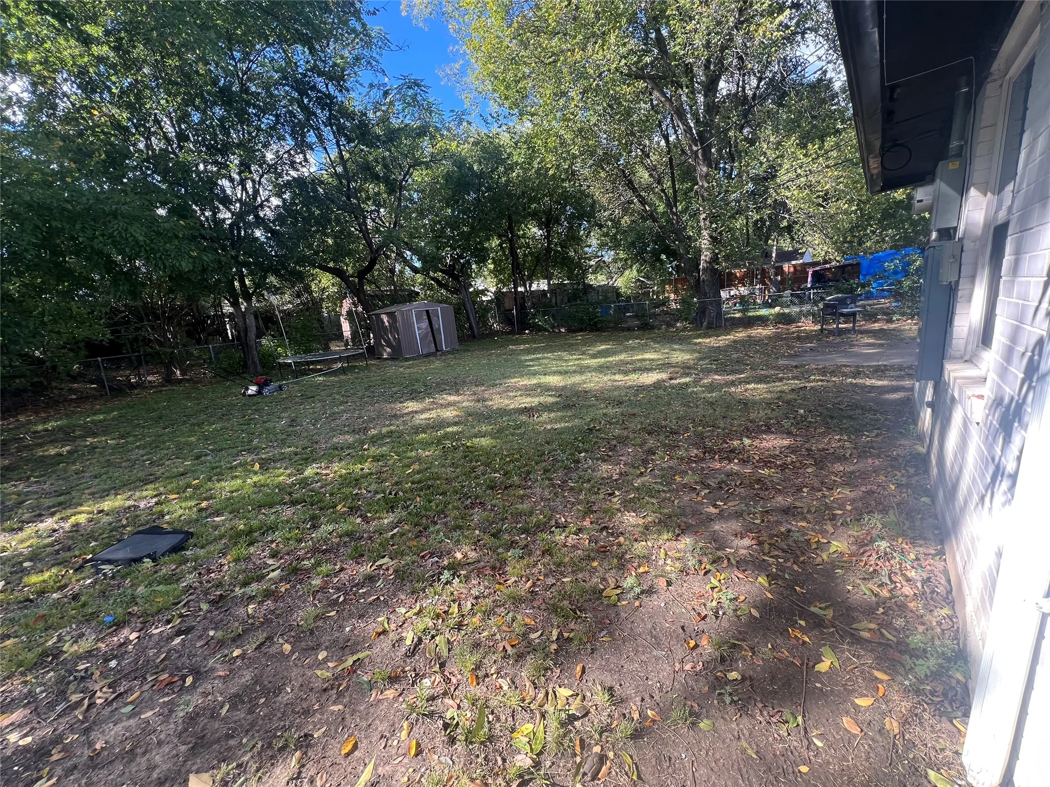 Fenced backyard featuring a shed