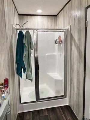 Full bath featuring a stall shower and dark wood-type flooring