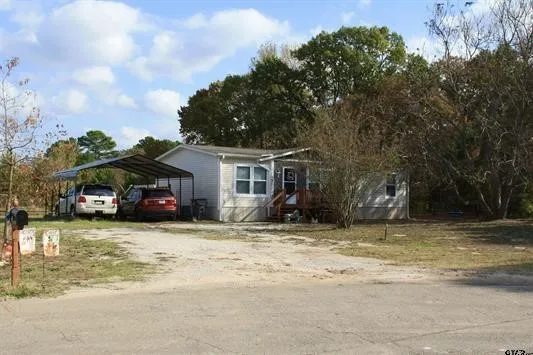 View of front of property with driveway and a carport