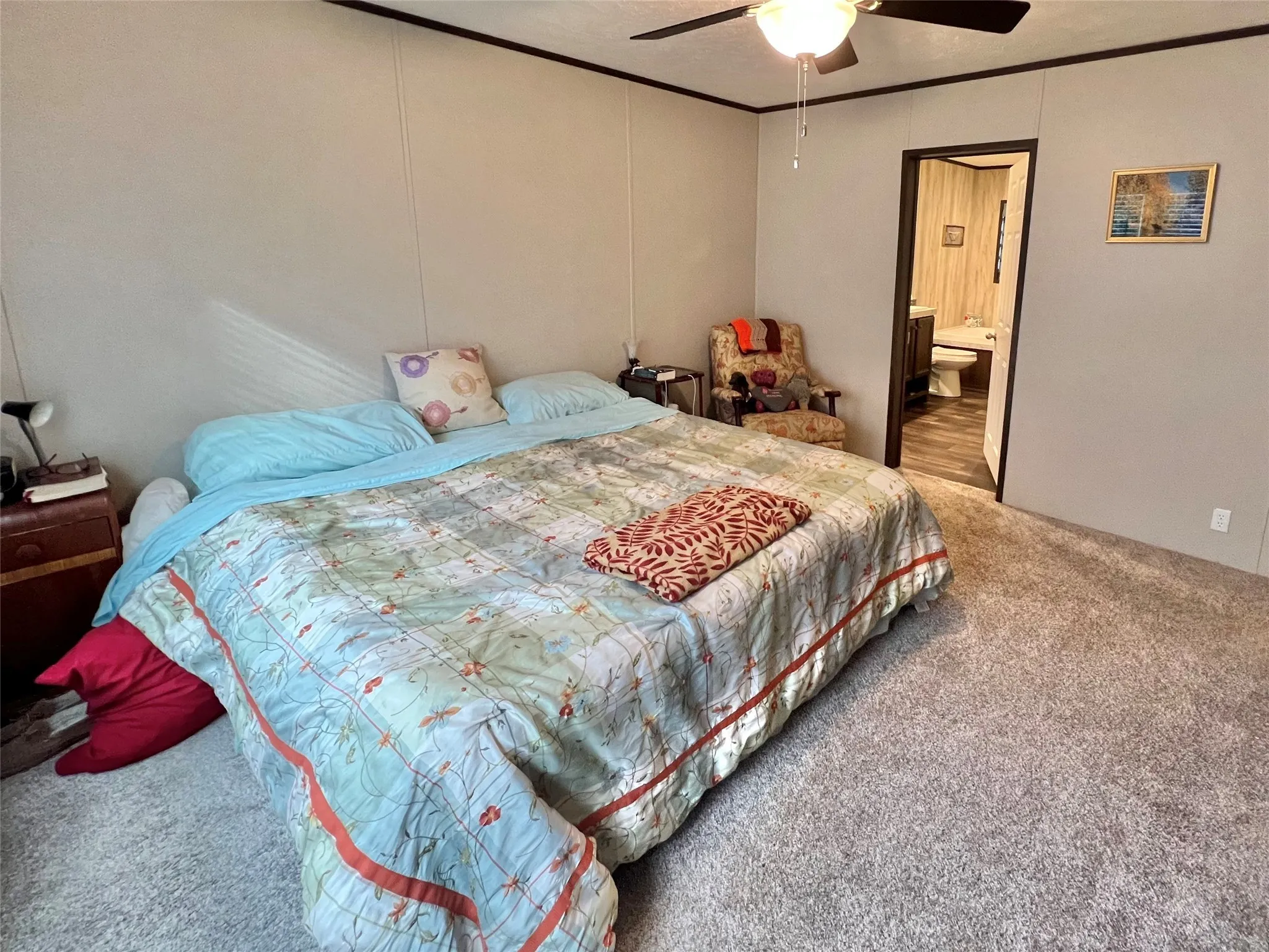 Bedroom with carpet flooring, ensuite bathroom, ceiling fan, and crown molding