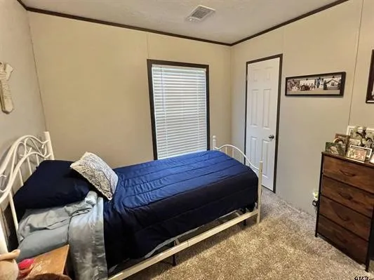 Bedroom with carpet floors and ornamental molding