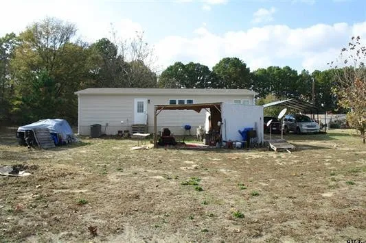 Rear view of house featuring a carport, a patio area, and a pergola