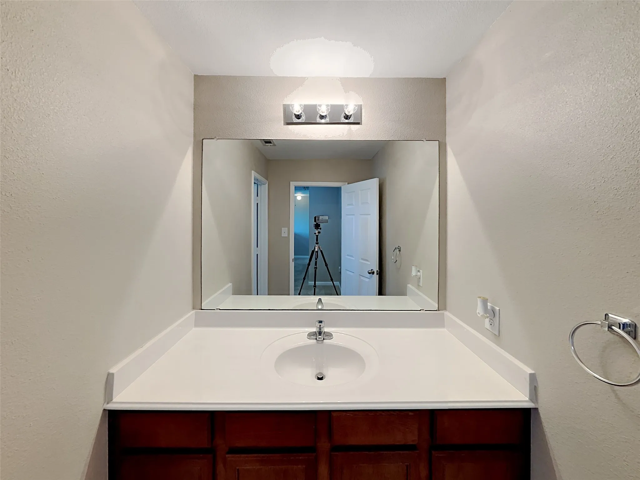Bathroom with a textured wall and vanity
