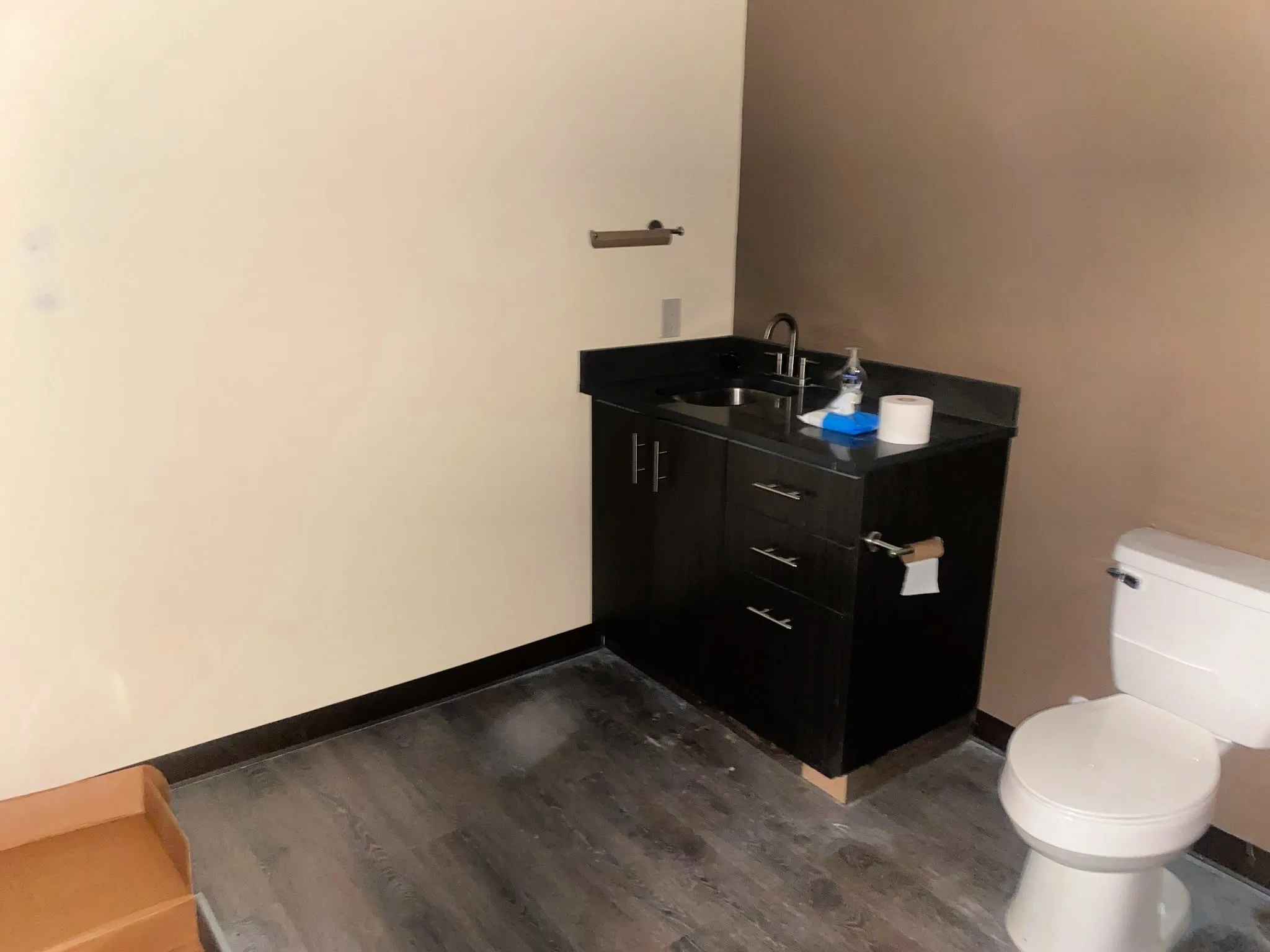 Half bathroom featuring vanity and dark wood-style flooring