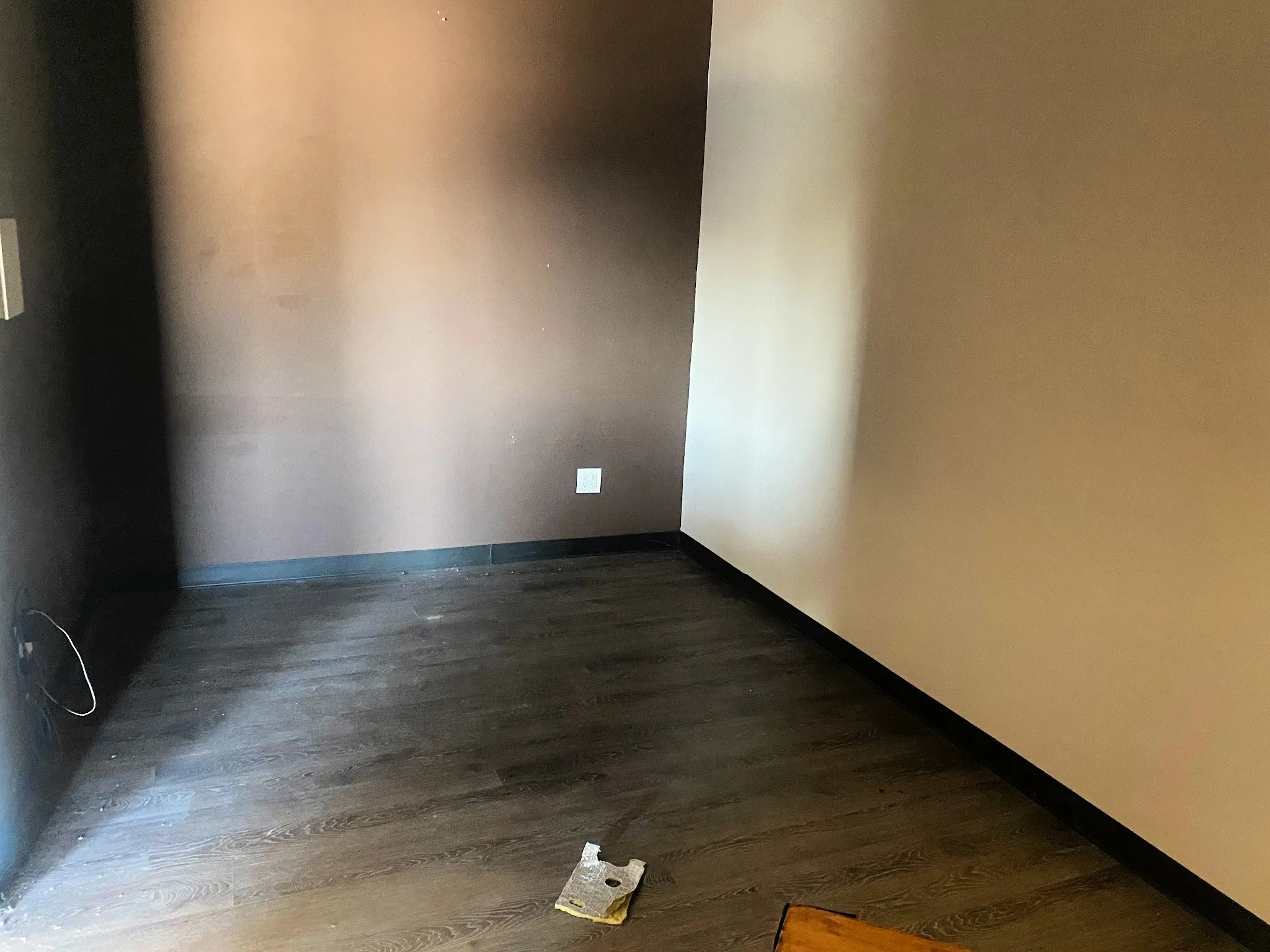 Empty room featuring dark wood finished floors and baseboards
