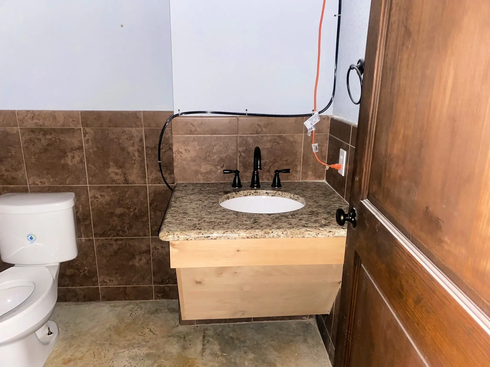 Bathroom featuring vanity, tile walls, and wainscoting