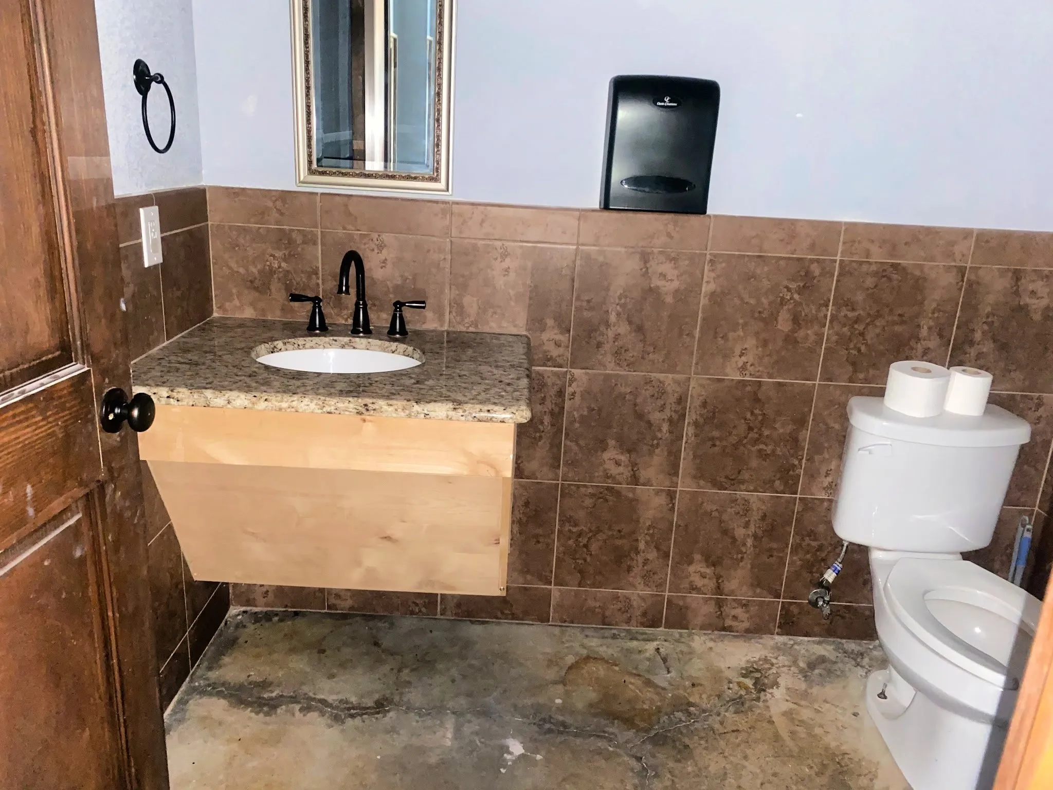 Half bathroom featuring vanity and tile walls