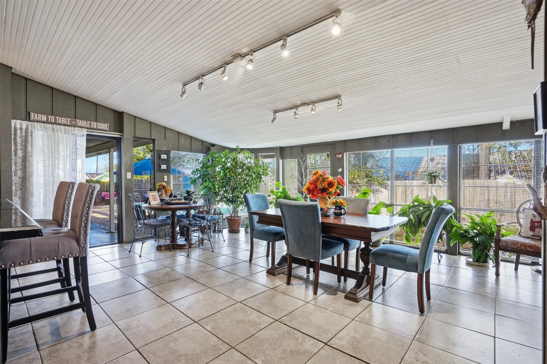 Tiled dining area featuring track lighting and lofted ceiling