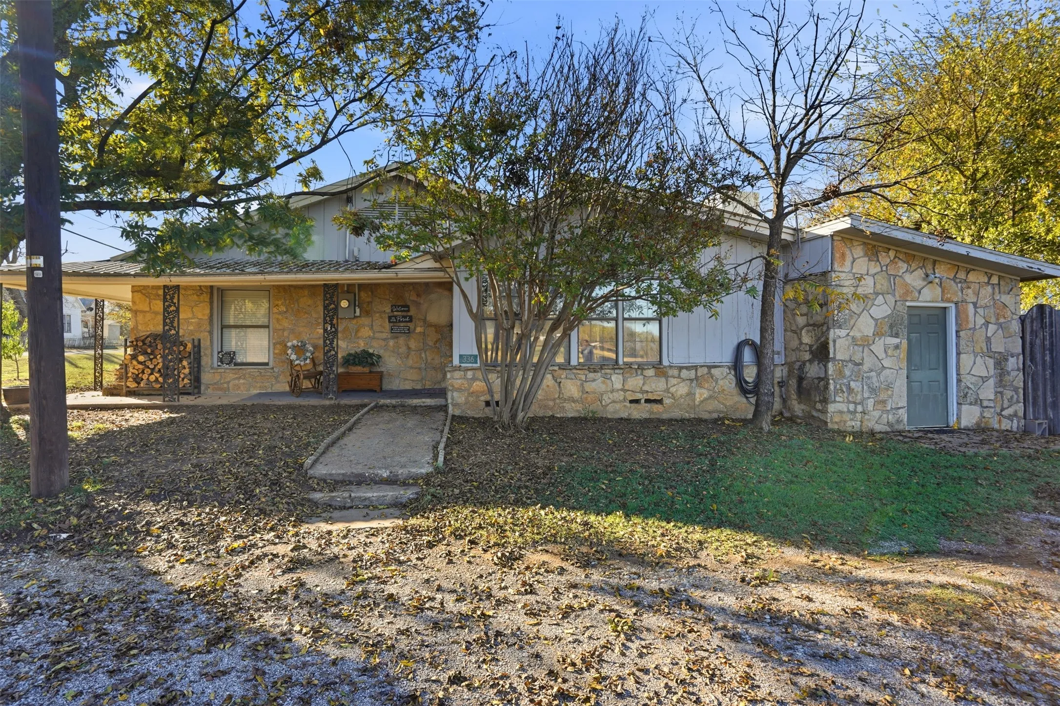 Rear view of property featuring stone siding, a porch, and board and batten siding