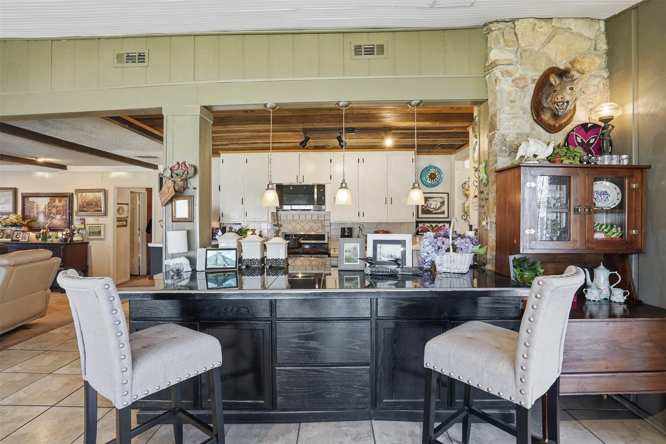 Kitchen featuring beamed ceiling, pendant lighting, a breakfast bar area, and appliances with stainless steel finishes