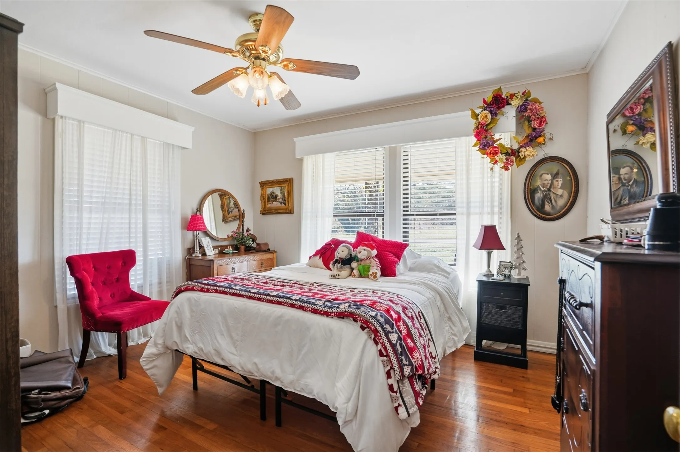 Bedroom featuring wood-type flooring, crown molding, and a ceiling fan