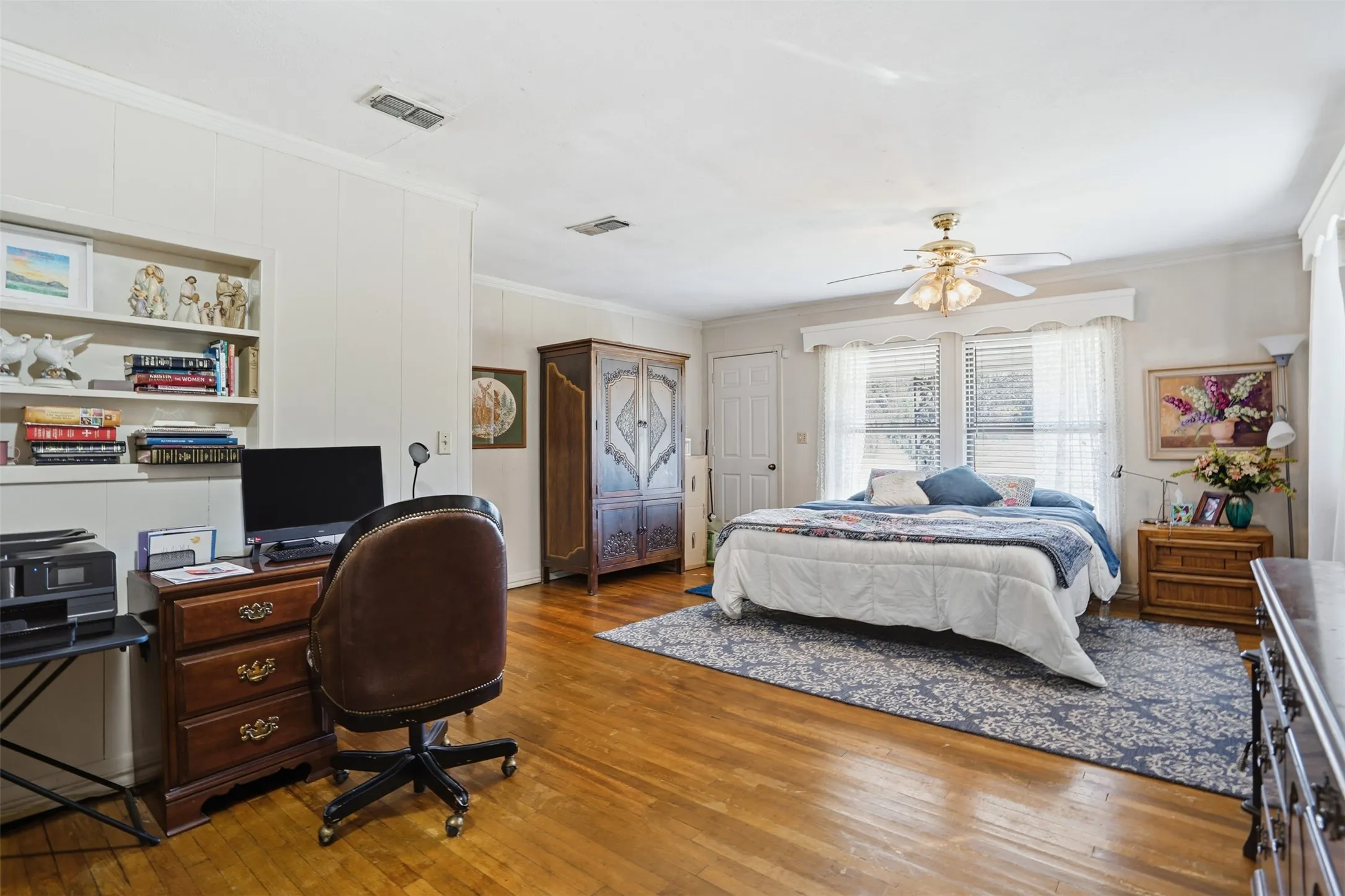 Bedroom with ornamental molding, a desk, hardwood / wood-style floors, a ceiling fan, and a closet