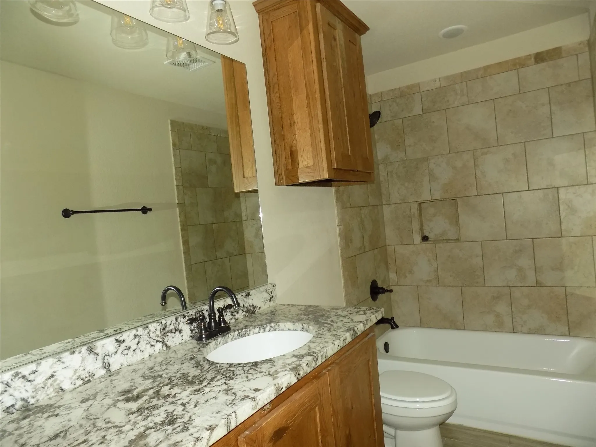 Guest bathroom with spacious cabinet space and lovely tile work.