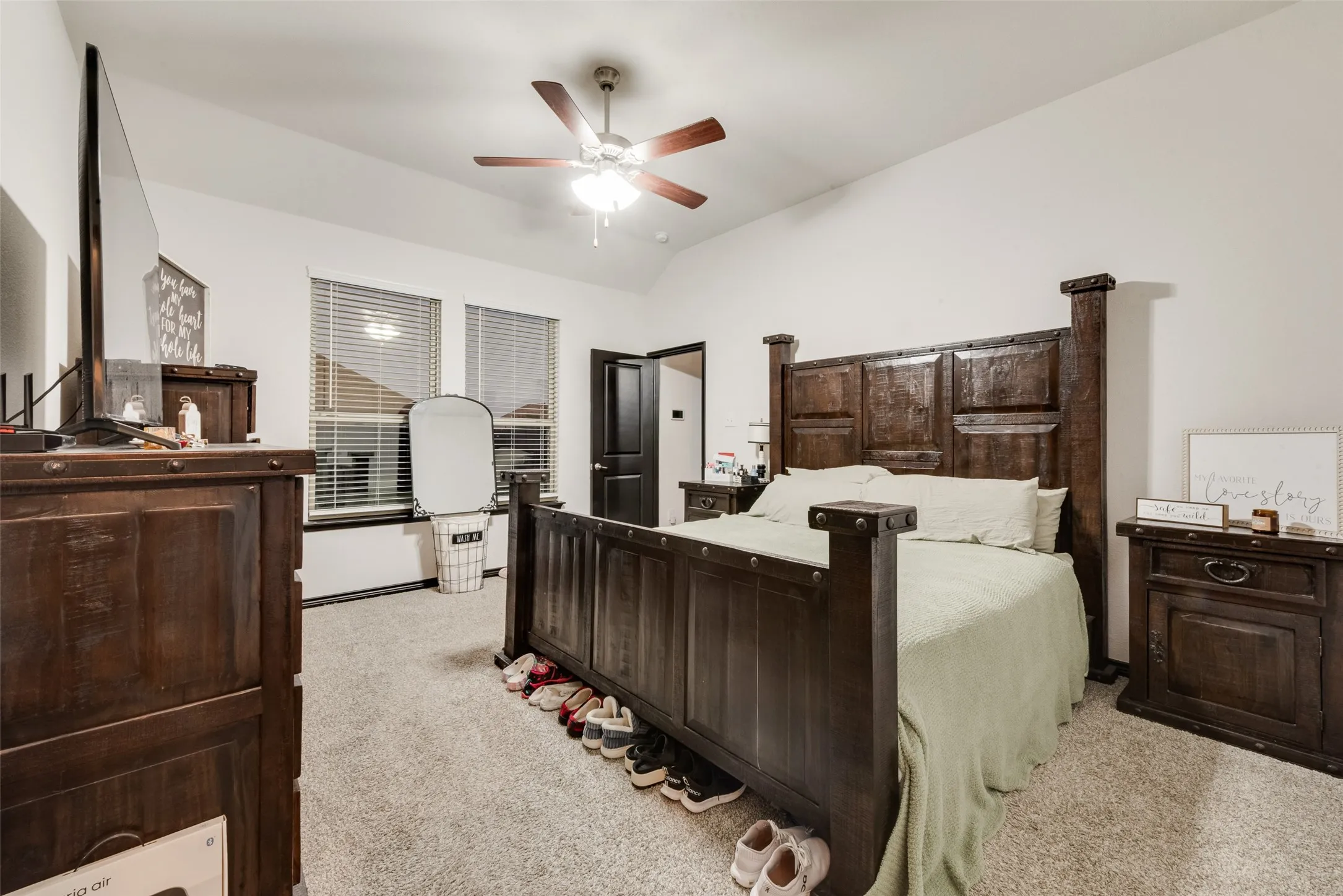 Bedroom featuring light colored carpet, lofted ceiling, and ceiling fan