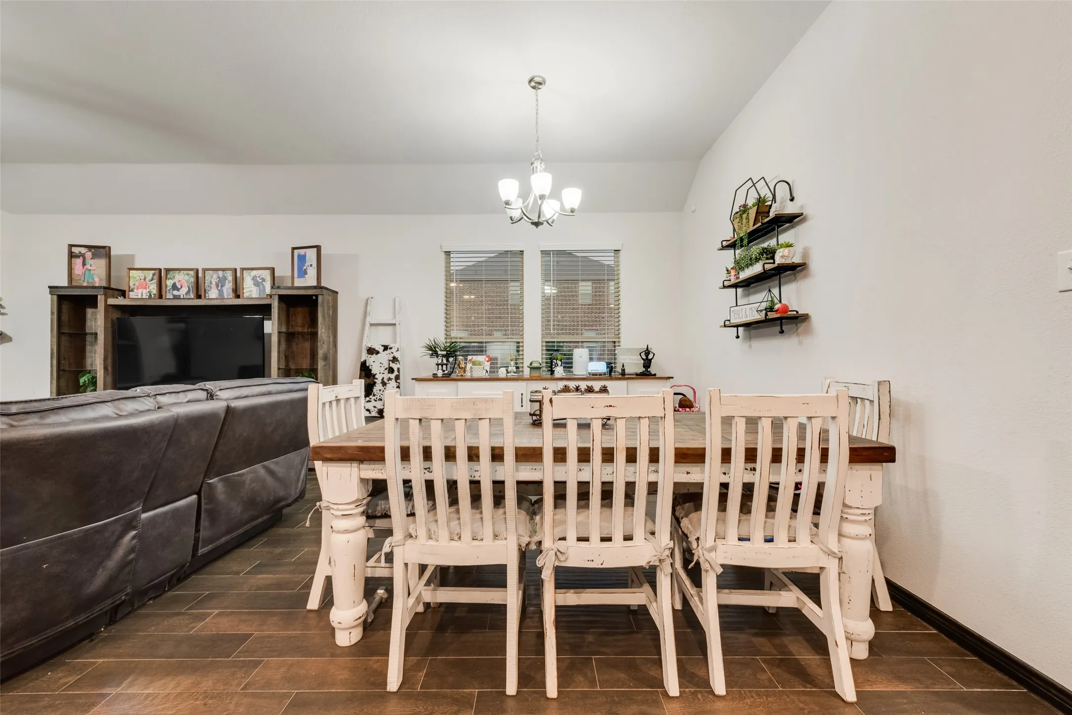 Dining room with wood tiled floors, a chandelier, and vaulted ceiling